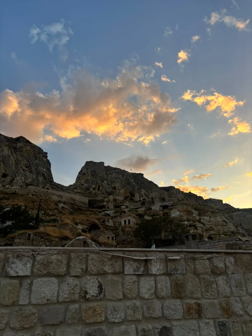 Las casas cueva excavadas en la roca de Uçhisar, en Capadocia, contra un cielo de atardecer