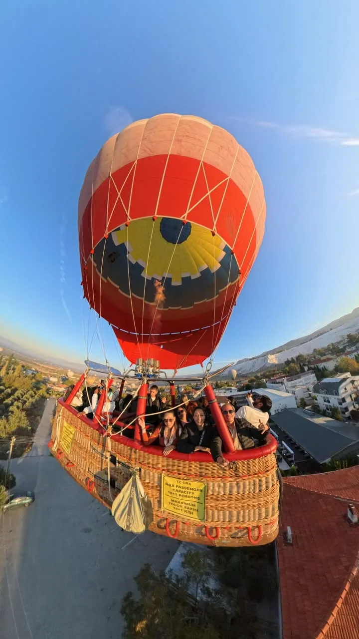 Grupo de viajeros en la cesta de un globo sobre Pamukkale al amanecer